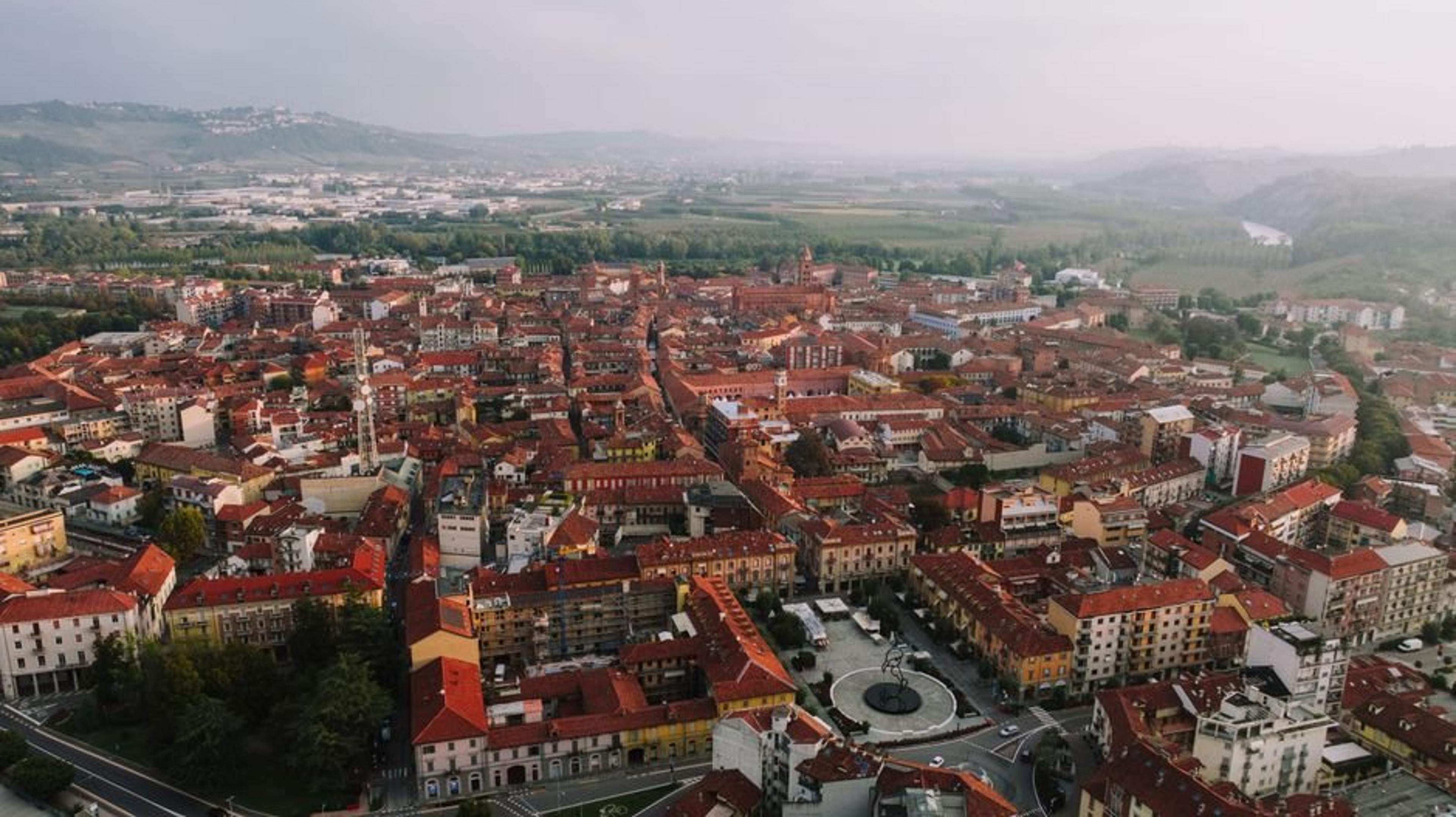 Drone shot capturing the beautiful terracotta rooftops of Alba, Italy, with surrounding countryside.